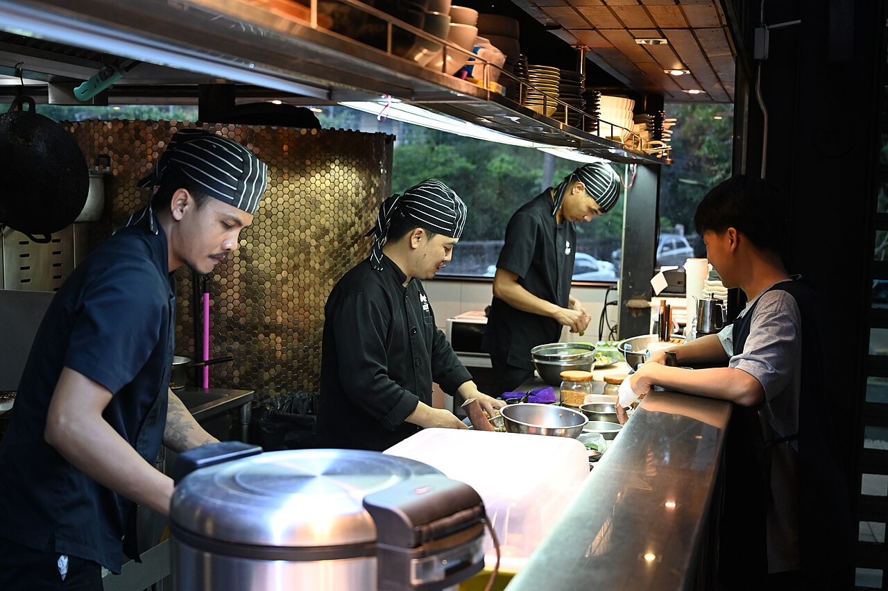 Kitchen staff working behind the counter of a busy restaurant