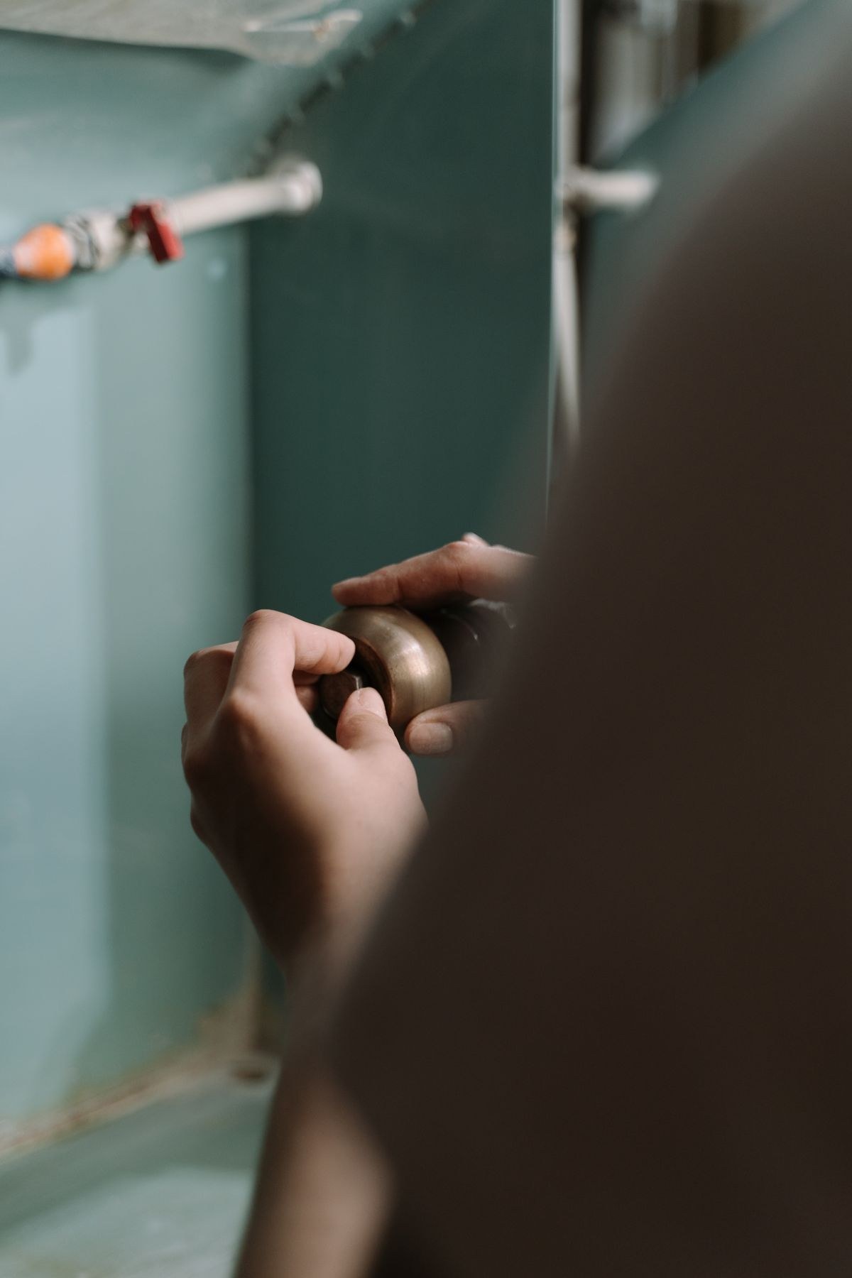 Hands repairing a plumbing fitting on a job